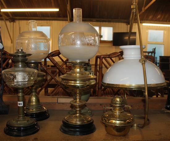 4 oil lamps and a brass hanging lamp with glass shade